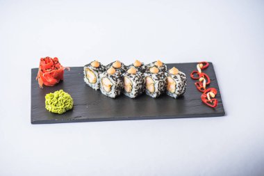 kayrak yönetim kurulu wasabin ve zencefil ile lezzetli Japon suşi rulo gri arka plan üzerinde görmek    