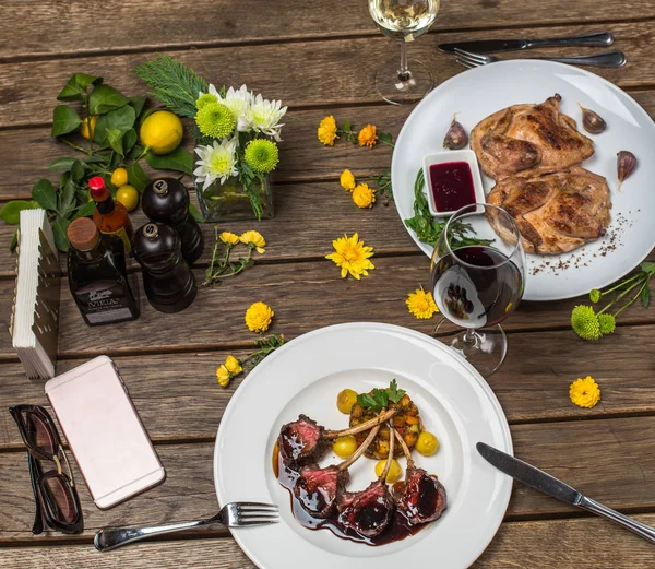 wooden setting table with meat dishes served on white plates