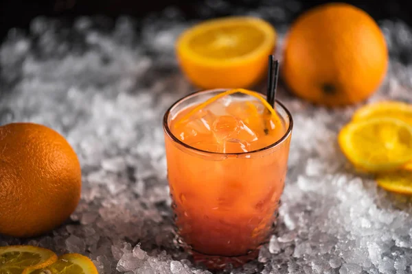 ガラス成分と氷の上でオレンジ色のカクテル — ストック写真