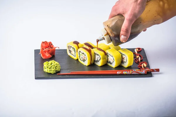 Человеческая Рука Льет Соус Традиционный Японский Суши Ролл Белом Фоне — стоковое фото