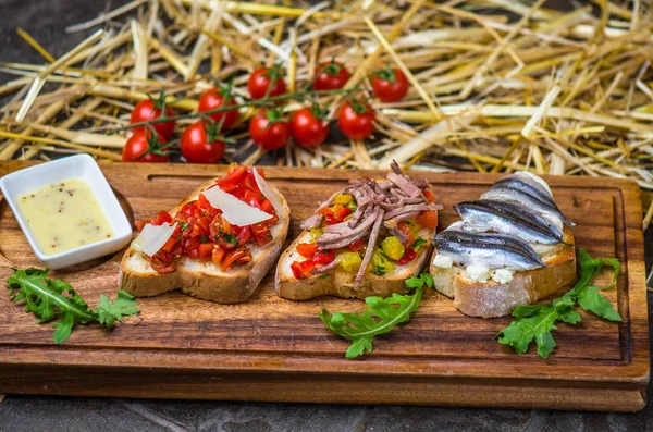 Bruschetta Snacks Vegetables Anchovy Served Wooden Board Rustic Background Straw — Stock Photo, Image