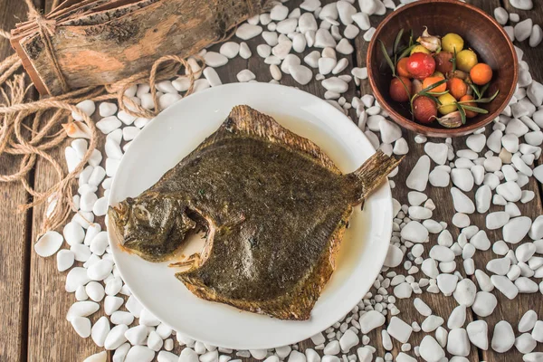 野菜のボウルで木製テーブルの上皿の唯一の魚のグリル — ストック写真