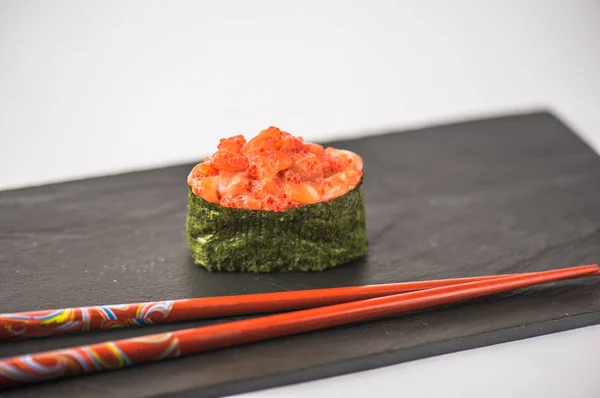 灰色の背景のスレート板で箸で美味しい寿司のクローズ アップ ビュー — ストック写真