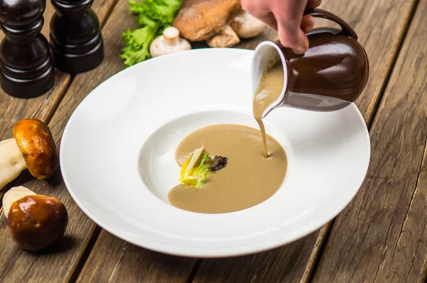 Human Hand Pouring Mushroom Cream Soup White Plate Wooden Table — Stock Photo, Image