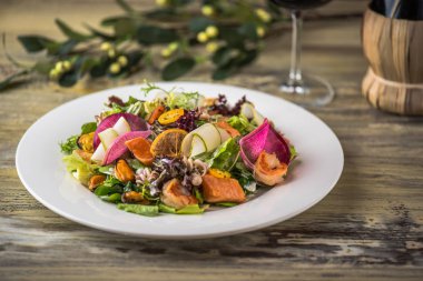 Ahşap masa üzerinde beyaz plaka üzerinde kızarmış tavuk ile sebze salatası