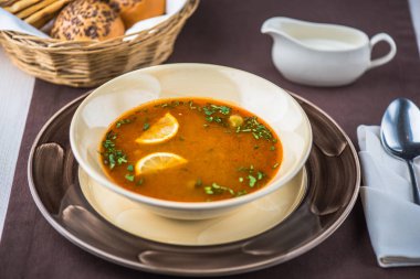 Ekmek ve kaşık ile masa örtüsü üzerinde çorba kase