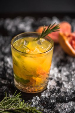 Buz ile koyu arka planda greyfurt ve biberiye ile cam kokteyl
