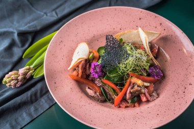 Çiçekli pembe plaka üzerinde meze et ve sebze ile servis