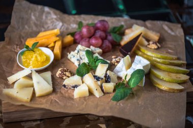 Parşömen üzerine peynir ve meyve meze eşliğinde
