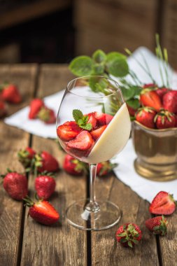 Tatlı şarap cam ahşap masa üzerinde servis krem ve taze çilek ile