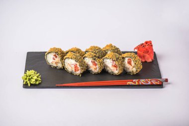 Japon suşi roll beyaz arka plan üzerinde yemek çubukları ile kayrak üzerinde servis tava