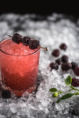 Kokteyl cam buz ile koyu arka plan üzerinde böğürtlen ile dekore edilmiş