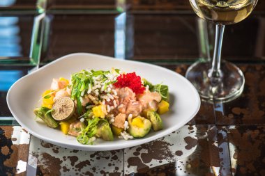 İncelik sebze salatası kadeh beyaz şarap ile koyu arka plan üzerinde tabakta servis