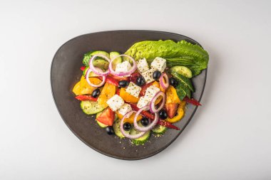 Beyaz arka plan üzerinde kase taze sebze Yunan salatası