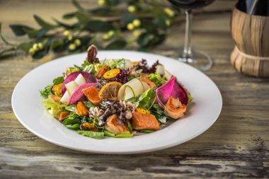 Ahşap masa üzerinde beyaz plaka üzerinde kızarmış tavuk ile sebze salatası