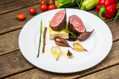 Ahşap masa üzerinde beyaz plaka üzerinde ızgara soğan ile balık