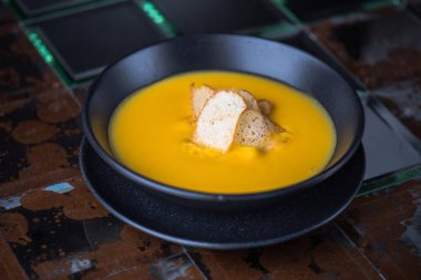 Siyah kase croutons süslenmiş krem balkabağı çorbası