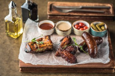 Farklı ızgara et ahşap tahta üzerinde kağıt üzerinde soslar ile devam eder