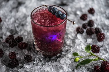 Stick buz ile koyu arka plan üzerinde yaban mersini taze kokteyl cam süslenmiş