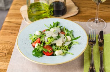 Ahşap masa üzerinde plaka üzerinde peynirli taze sebze salatası