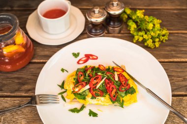 Ahşap masa tabakta servis taze sebze ile kızartılmış omlet ile kahvaltı