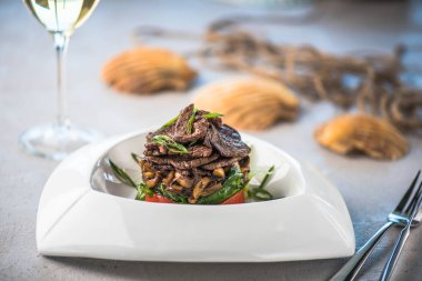 Beyaz tabakta et ve sebze yemek