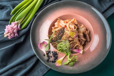 İtalyan makarna ile karanlık masa örtüsü tabakta servis et