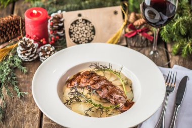 Kavrulmuş dilimlenmiş et ve patates ile Noel dekor ahşap masa üzerinde plaka üzerinde