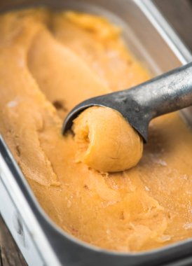 şeftalili dondurma kaşık ile kapsayıcısında closeup