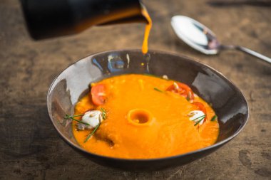 ahşap masa üzerinde sürahi kase içinde peynirli sebze çorbası bırakarak