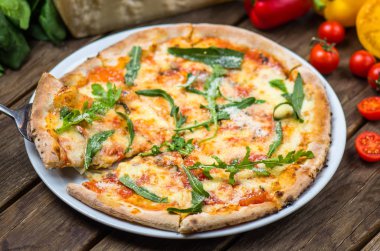 parmesan peynir, roka ve domates gurme pizza ahşap masa üzerinde görmek