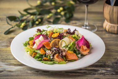 Ahşap masa üzerinde beyaz plaka üzerinde kızarmış tavuk ile sebze salatası