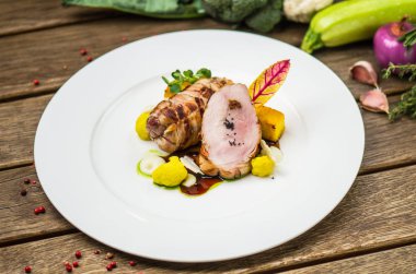 Beyaz ahşap masa üzerinde sebzeli tabakta kavrulmuş domuz eti