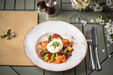 Buğulanmış sebze somon dilimleri ve yumurta pashot üst plaka ayarı tablo üzerinde devam eder