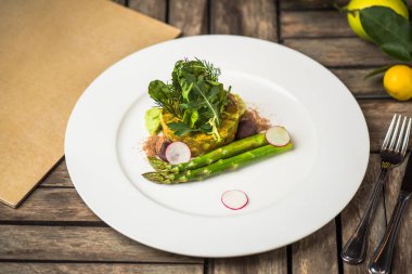 Ahşap masa tabakta servis kuşkonmaz ile sebze meze