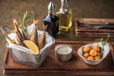 Sepet ve peynir topları Cafe ahşap masa üzerinde soslu kızarmış balık  