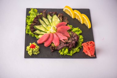 Beyaz arka planda arduvaz üzerinde taze Japon deniz ürünleri sashimi