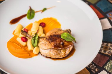 Renkli mozaik zemin üzerine beyaz tabakta ördek bacak garnitür ile servis