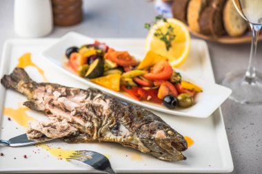 Izgara balık tabakta taze sebze salatası ve limon ile