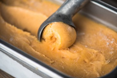 şeftalili dondurma kaşık ile kapsayıcısında closeup