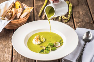 ahşap masa üzerinde plaka ile hamur tatlısı kremalı sebze çorbası dökme