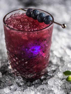 Stick buz ile koyu arka plan üzerinde yaban mersini taze kokteyl cam süslenmiş