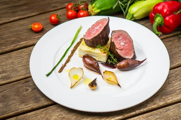 Ahşap masa üzerinde beyaz plaka üzerinde ızgara soğan ile balık