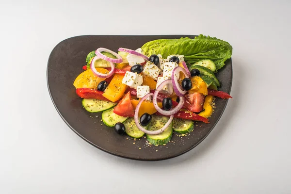 Beyaz arka plan üzerinde kase taze sebze Yunan salatası