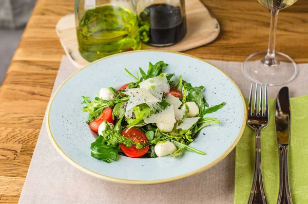Ahşap masa üzerinde plaka üzerinde peynirli taze sebze salatası