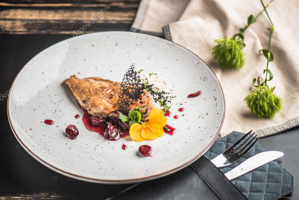 Chicken breast served on plate with gravy and decor