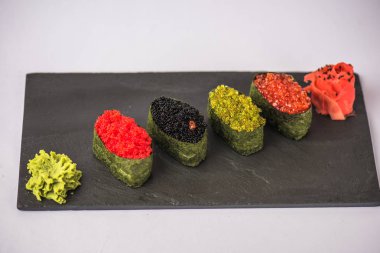 wasabi ve zencefil ile lezzetli suşi gri arka plan üzerinde kayrak gemide görmek