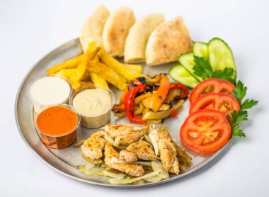 çerez tabağı taze ve kızarmış sebze, tavuk, soslar ve beyaz zemin üzerine ekmek