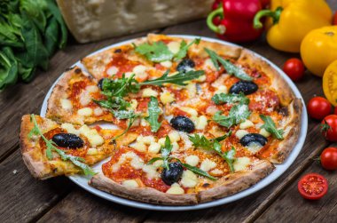 Roka ve ahşap masa tabakta servis zeytin İtalyan pizza