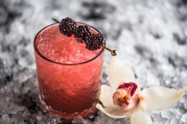 Kokteyl cam buz ile koyu arka plan üzerinde böğürtlen ile dekore edilmiş